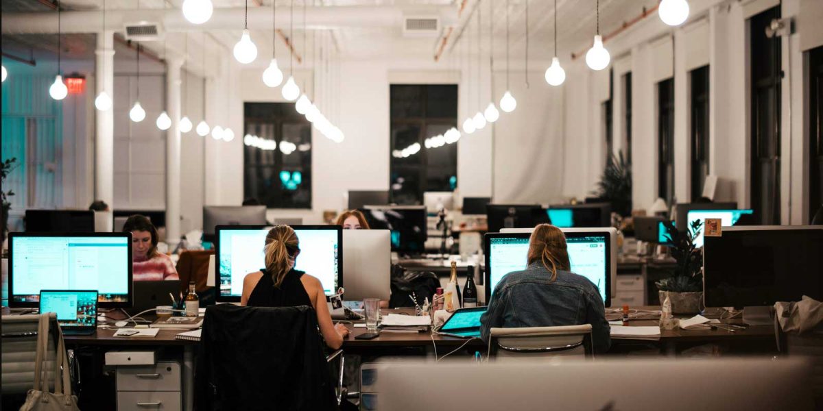 A candid photo of a startup office at night, with several employees deeply focused on their work.