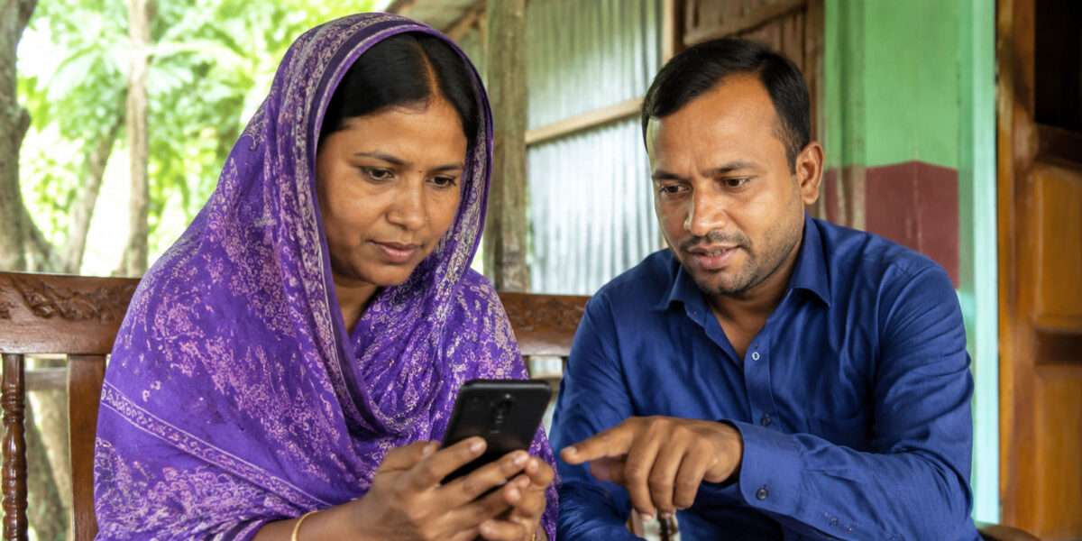 Bangladeshi woman reviewing smartphone privacy settings with guidance from a man